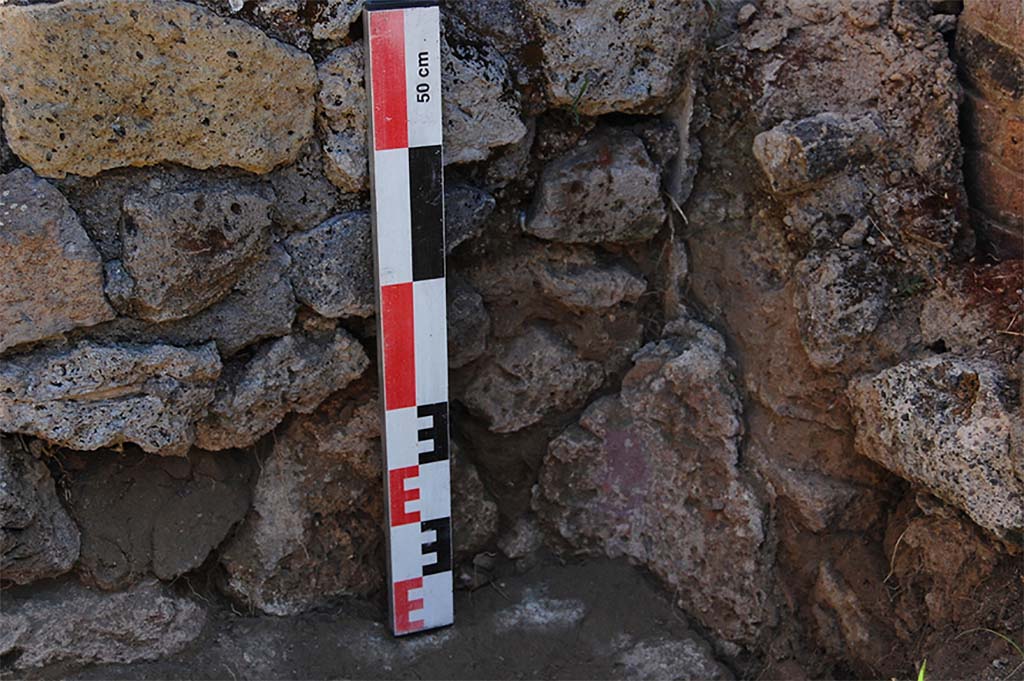 Fig. 26 – Pompéi, boulangerie VII 2, 3.6 – Angle sud-oriental du péristyle, au point de contact entre le bassin et le bras méridional.
Vue du nord-ouest.
La succession des enduits et mortier permet de suivre les trois phases : construction du péristyle, aménagement du bassin, réfection de la rigole.
Cliché : N. Monteix – EFR.
