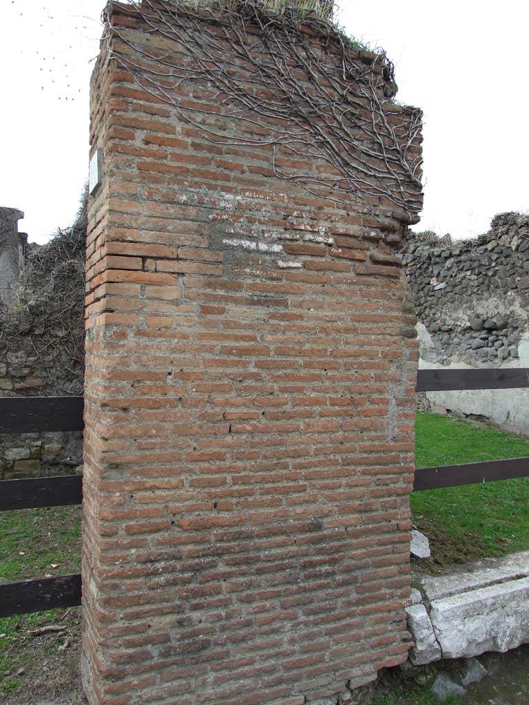 VII.2.11 Pompeii.  December 2007. Pillar between VII.210 and VII.2.11. There was formerly a painting on the pillar.  
This represented a bearded man carrying an object on a pole, which had the appearance of a garment fresh from the dye.
See Mau, A., 1907, translated by Kelsey F. W. Pompeii: Its Life and Art. New York: Macmillan. (p.385-6).
