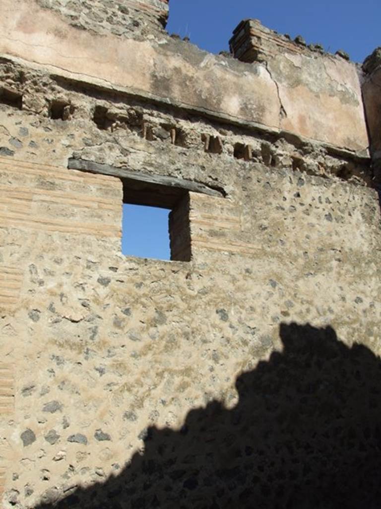 VII.2.18 Pompeii. March 2009. Room 2, north wall with window to Vicolo del Panettiere. Upper floor (separate apartment with access from VII.2.19) with window and remains of wall plaster.

