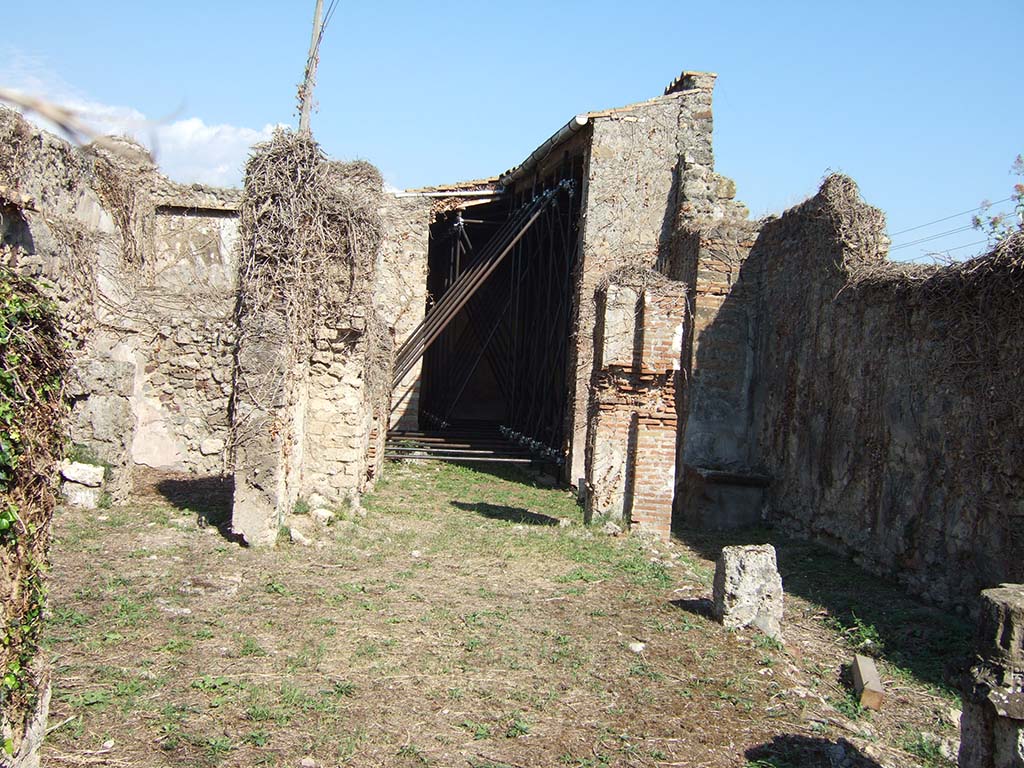 VII.2.25 Pompeii. September 2005. Looking east into atrium with the remains of three-sided portico.
The portico used to have a pluteus (low wall) between the columns, now vanished.
