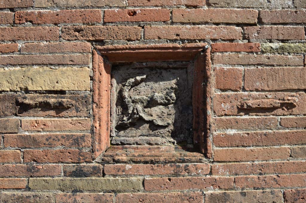 VII.2.32, Pompeii. March 2018. Plaque showing a flying phallus, between two others on wall between VII.2.31 and VII.2.32.
Foto Taylor Lauritsen, ERC Grant 681269 DCOR.
