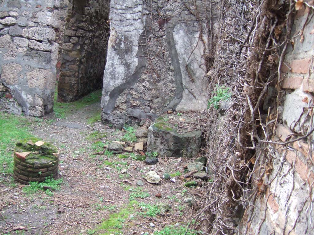 VII.2.51 Pompeii. December 2005. 
South-east corner of viridarium with masonry bench and door to corridor leading to kitchen and oven.
