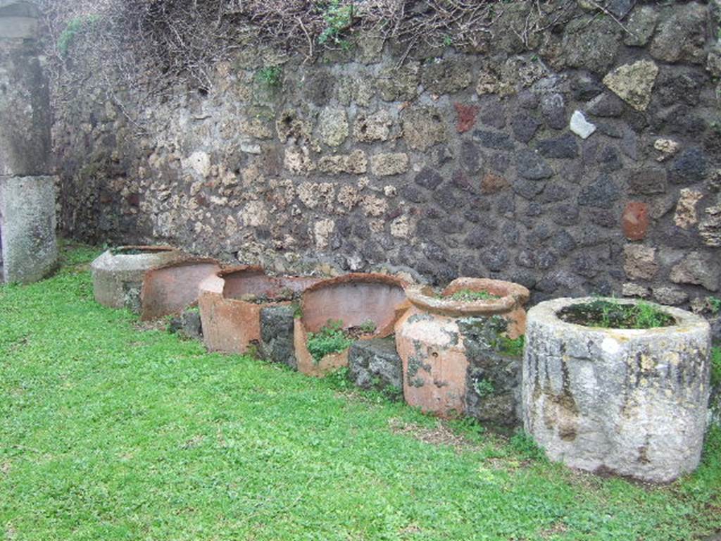 VII.3.3 Pompeii. December 2005. Travertine basin and five urns against the west wall.