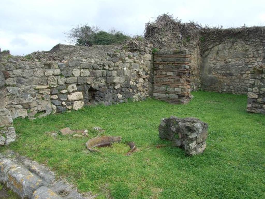 VII.3.4 Pompeii. March 2009. East side of shop, looking south east across site of  counter, with remains of 3 urns.