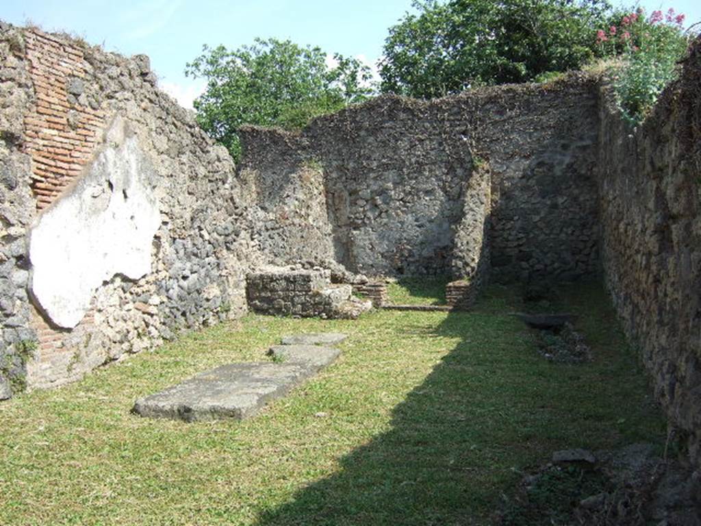 VII.3.10 Pompeii. May 2006. Looking south across shop towards steps to upper floor in front of rear room, on left. Four lava paving slabs are laying on the ground to the left.
