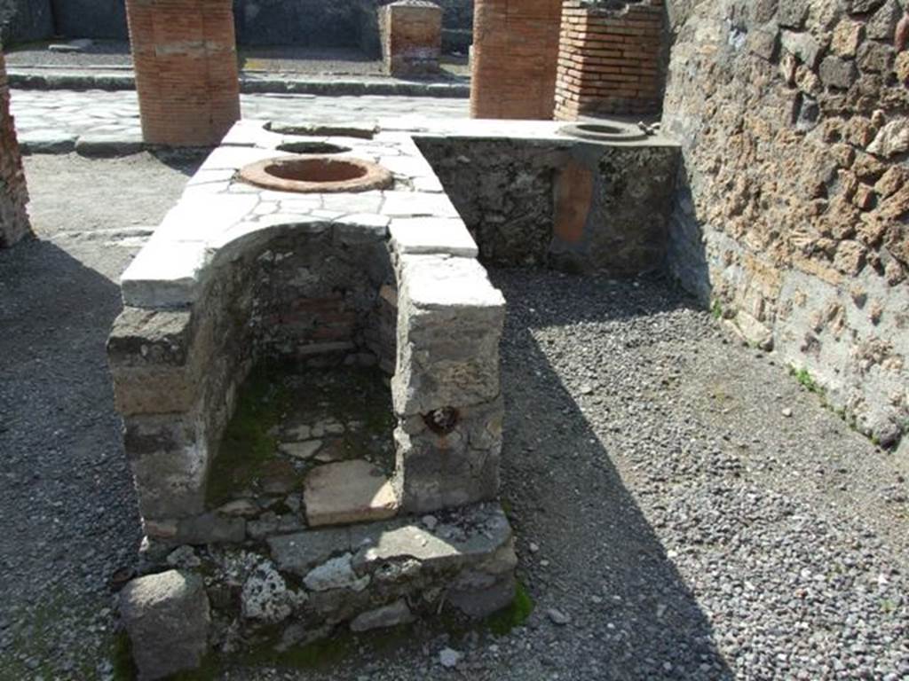 VII.4.4 Pompeii. March 2009.  Looking west towards Via del Foro, from rear of counter with hearth on its eastern end.
