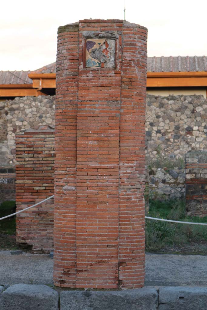 VII.4.6 Pompeii. December 2018. 
Masonry pillar and plaque in portico on east side of Via del Foro. Photo courtesy of Aude Durand.
