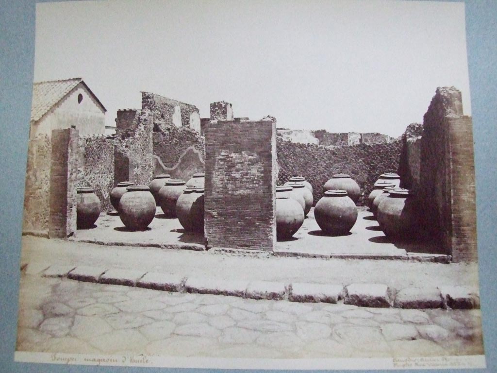 VII.4.13 Pompeii and VII.4.14. Via Foro oil shop. 19th century photograph by Amodio. 
Photo courtesy of the Society of Antiquaries, Fox Collection. 
Fiorelli says the two adjacent large shops had these dolia temporarily deposited in them.  
They had come from outside Pompeii near “il Sarno”.  
Some of these are now to be found outside the city wall below the Temple of Venus and the Sarno Baths.
See Pappalardo, U., 2001. La Descrizione di Pompei per Giuseppe Fiorelli (1875). Napoli: Massa Editore. (p.89).
