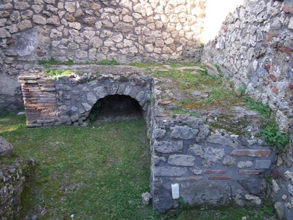 VII.4.31 Pompeii. March 2009. Room 36, kitchen with bench and hearth. Looking north. According to Boyce, Helbig saw the remains of a fragmentary lararium painting with the figures of the Lares. No longer visible.
See Boyce G. K., 1937. Corpus of the Lararia of Pompeii. Rome: MAAR 14. (p. 66)  
