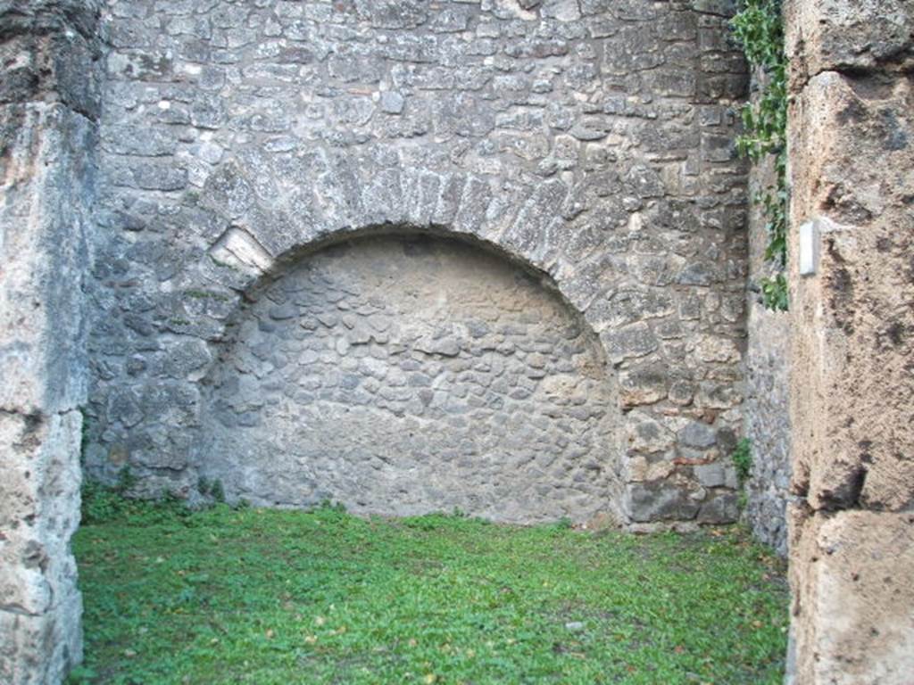 VII.4.35 Pompeii. December 2004. Looking west through doorway towards rear wall with arched niche. On the outside wall between VII.4.34 and 35 were painted figures of Mercury and Bacchus. See Boyce G. K., 1937. Corpus of the Lararia of Pompeii. Rome: MAAR 14. (p.111, no.17 

