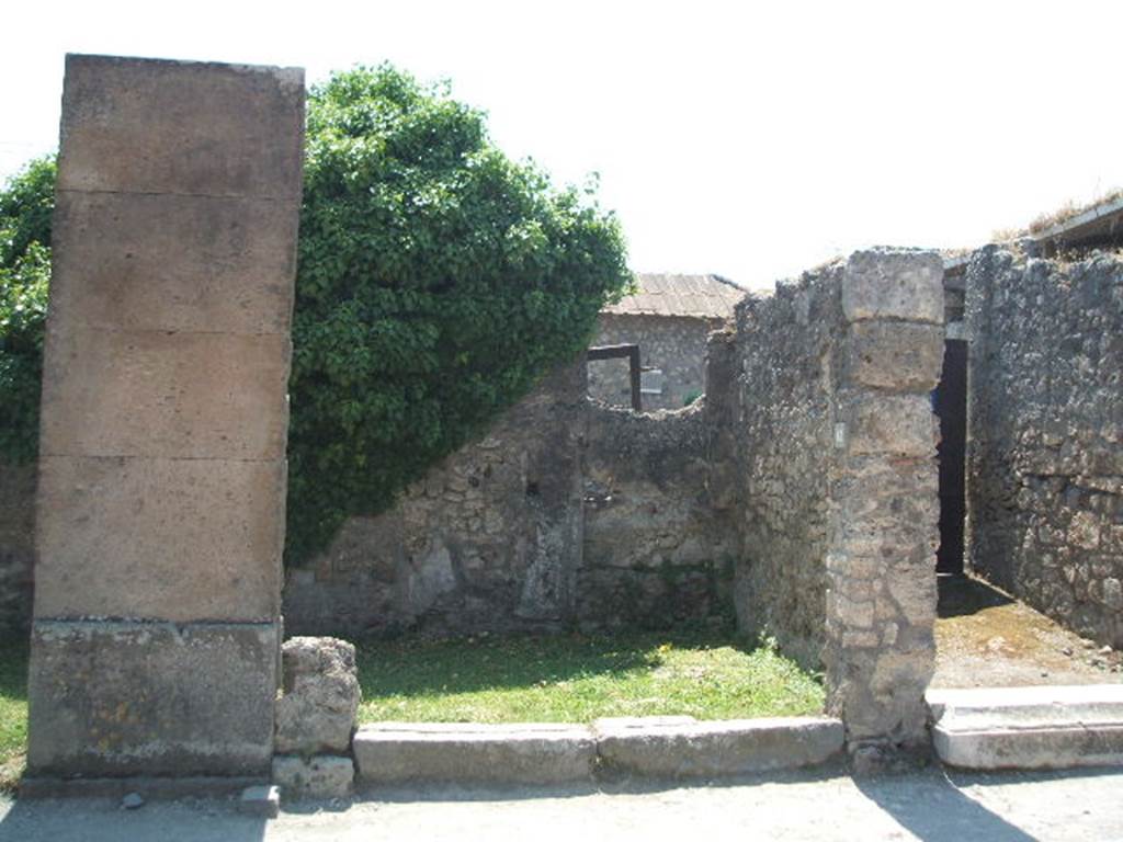 VII.4.61 Pompeii. May 2005. Entrance, looking south to rear wall with blocked doorway to VII.4.62.
On the pilaster between VII.4.60 and 61 (on the left, see also VII.4.60), an inscription was found (CIL IV 275) traced in bright red:
 C.  CVSPIVM  PANSAM
AED.  D. R. [P.]  O. V. F.  SATVRNINVS
CVM  DISCENTES  [sic]  ROG(at)
See Garcia y Garcia, L., 2005. Pupils, Teachers and Schools in Pompeii. Roma: Bardi editore. (p. 84)



