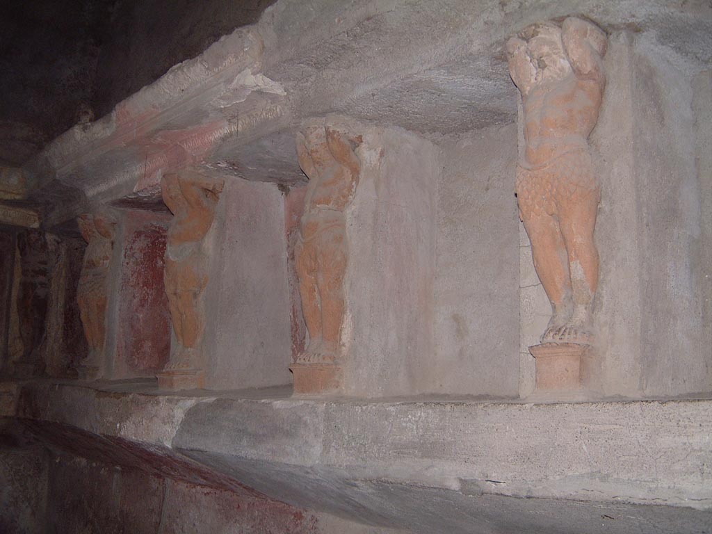 VII.5.24 Pompeii. May 2001. Tepidarium (37), looking west along north wall, detail of telamons separating the niches. 
Photograph courtesy of Current Archaeology.
