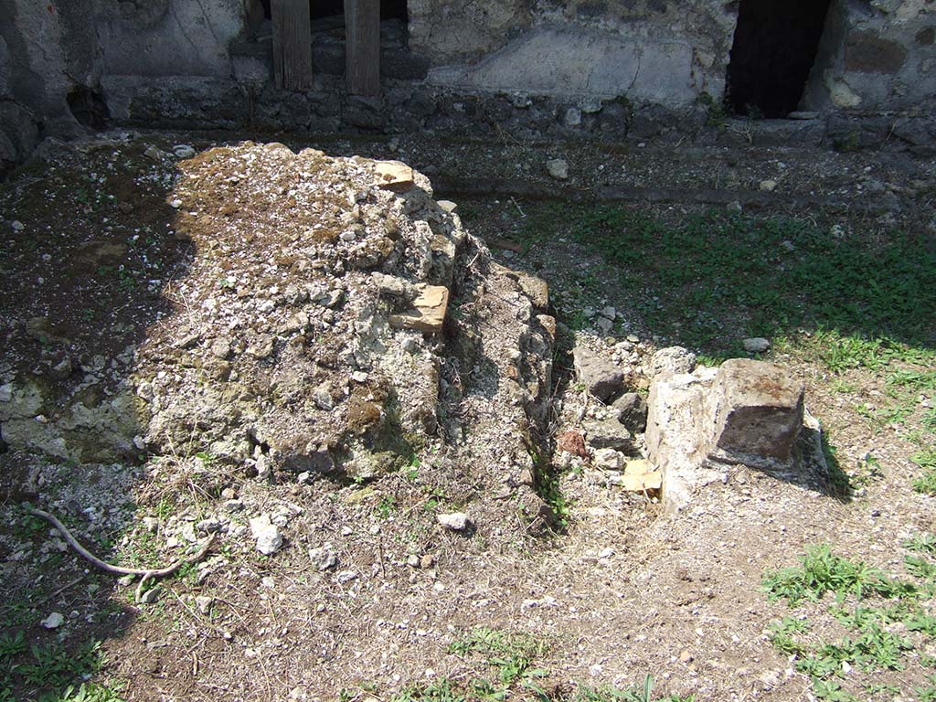 VII.6.3 Pompeii. September 2005. Room 18, viridarium in south-west corner of the peristyle.
Remains of base (r) of a Temple Lararium shrine, on which the statue of Diana was found, with the small altar in front.
