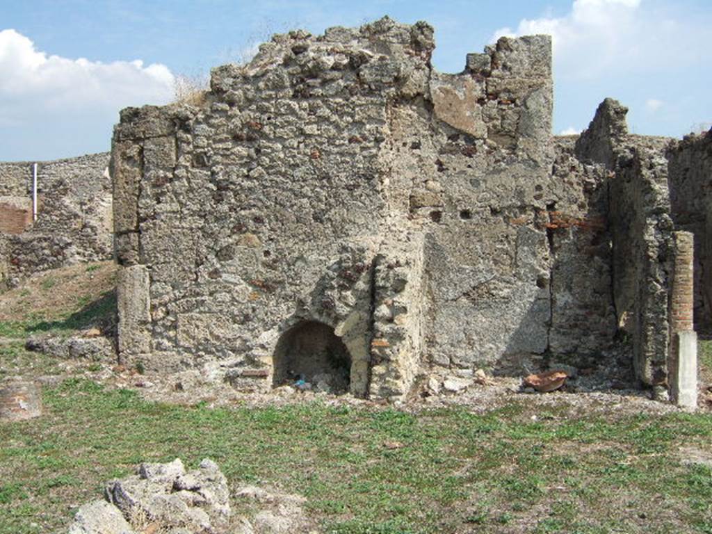 VII.6.7 Pompeii. September 2005. Stairs of the east wall of the peristyle of VII.6.7 are on the left,  The east wall of the latrine of VII.6.7 is centre left,  and VII.6.28 on the right, behind the column. According to Spano in NdS, at the rear of the eastern walkway (of the peristyle) there was a brick staircase with an arch below.  This staircase led up to some rooms existing above the ground floor rooms numbered 56 and 57. The entry to these two rooms was through a small doorway on the right of the staircase. Of these two rooms, number 56 was the latrine, and number 57 was the kitchen. See Spano in Notizie di Scavi, 1910, (p.460)
