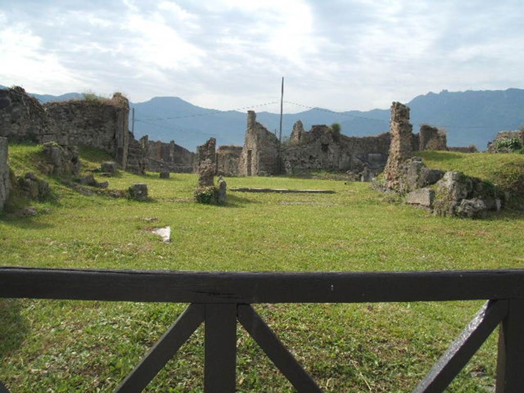 VII.6.8 Pompeii. May 2005.  In the foreground behind the wooden gate, would have been the site of the shop at VII.6.8. In the background behind the shop would have been the house at VII.6.7.
