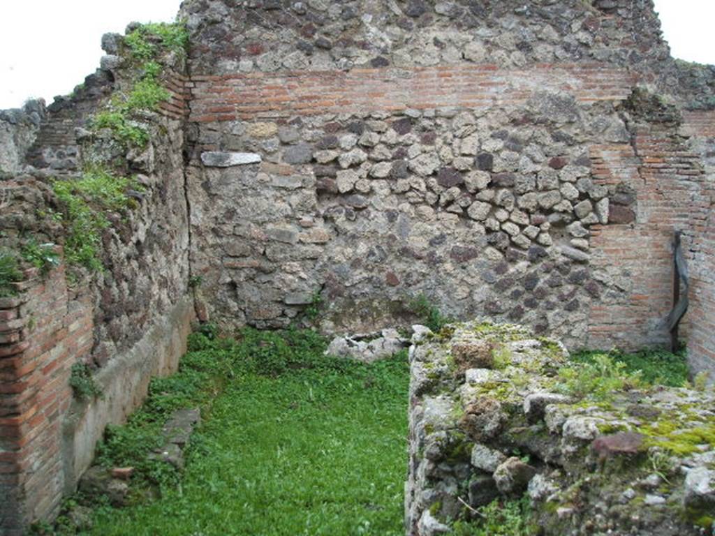 VII.6.15 Pompeii. December 2004. Looking west across south side of bar-room. In the south wall, in the left-front of the photo, is a doorway leading through to the long room.  In the south-west corner at the rear can be seen the remains of a structure. Fiorelli called it  un sedile di Fabbrica (a seat of masonry).  Eschebach called it a zweischenkeliger Herd (a two-legged hearth).
See Pappalardo, U., 2001. La Descrizione di Pompei per Giuseppe Fiorelli (1875). Napoli: Massa Editore.(p.160)
See Eschebach, L., 1993. Gebudeverzeichnis und Stadtplan der antiken Stadt Pompeji. Kln: Bhlau. (p.294)
