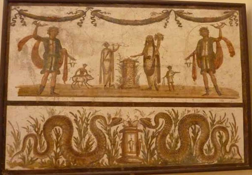 VII.6.38 Pompeii. May 2010. Lararium painting. The upper part has an offering scene.  A round altar is in the centre.  The offering Genius has a small camillus helping on his right.  On the other side of the altar is the tibicen with a popa assisting with a small pig.  The scene is flanked on either side by a large lar.  Above the scene are three garlands. The lower part has two serpents, in plants, approaching a second round altar, one from either side. Fröhlich says this as found  Reg.  VII or VIII.  
See Fröhlich, T., 1991. Lararien und Fassadenbilder in den Vesuvstädten. Mainz: von Zabern. (L98, T: 10,2).
Pagano and Prisciandaro show this as being from VII.6.38.
See Pagano, M., and Prisciandaro, R., 2006. Studio sulle provenienze degli oggetti rinvenuti negli scavi borbonici del regno di Napoli.  Naples : Nicola Longobardi.  (p.39).
Now in Naples Archaeological Museum. Inventory number: 8905.
