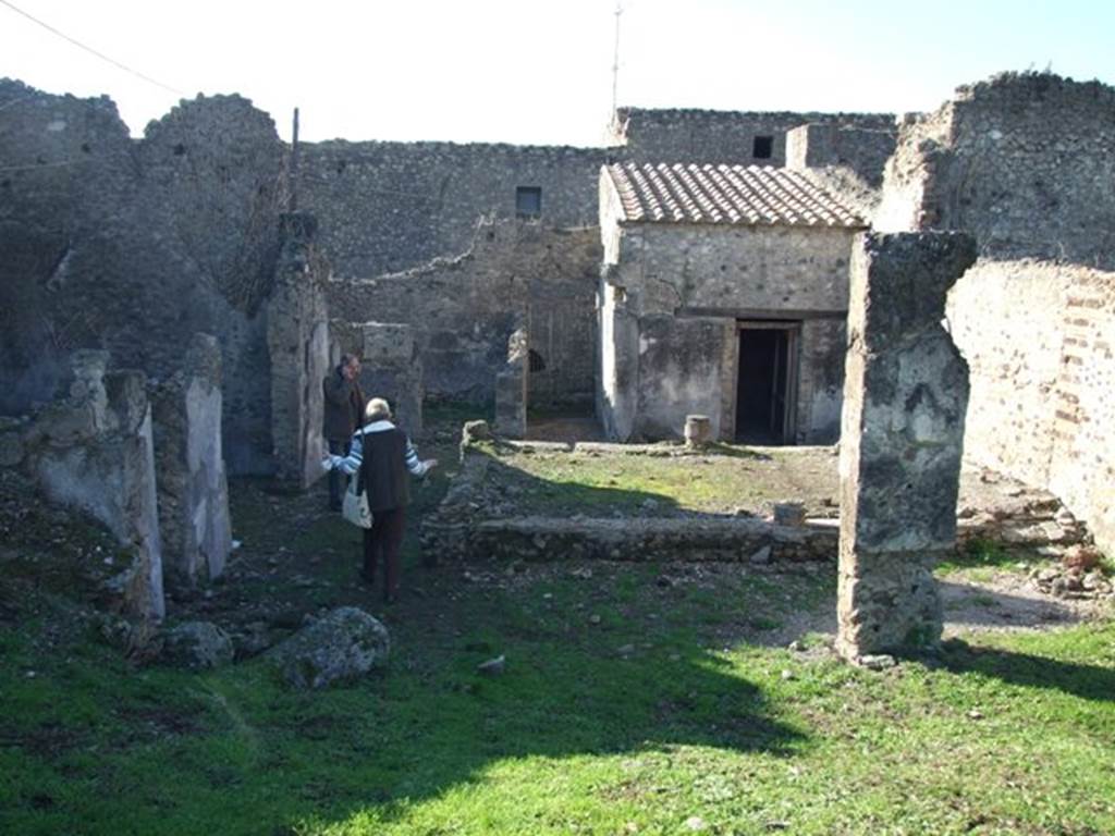 VII.6.38 Pompeii. December 2007. Looking west across portico to entrance, from area of oecus or tablinum.  Another oecus is to the north and a triclinium to south of entrance.  The portico would have been supported by the four columns, of which only a small lower area of each survives. According to Jashemski, these were plastered and painted red and at the time of excavation did not have capitals. They were connected by a low masonry wall. See Jashemski, W. F., 1993. The Gardens of Pompeii, Volume II: Appendices. New York: Caratzas. (p.185)



