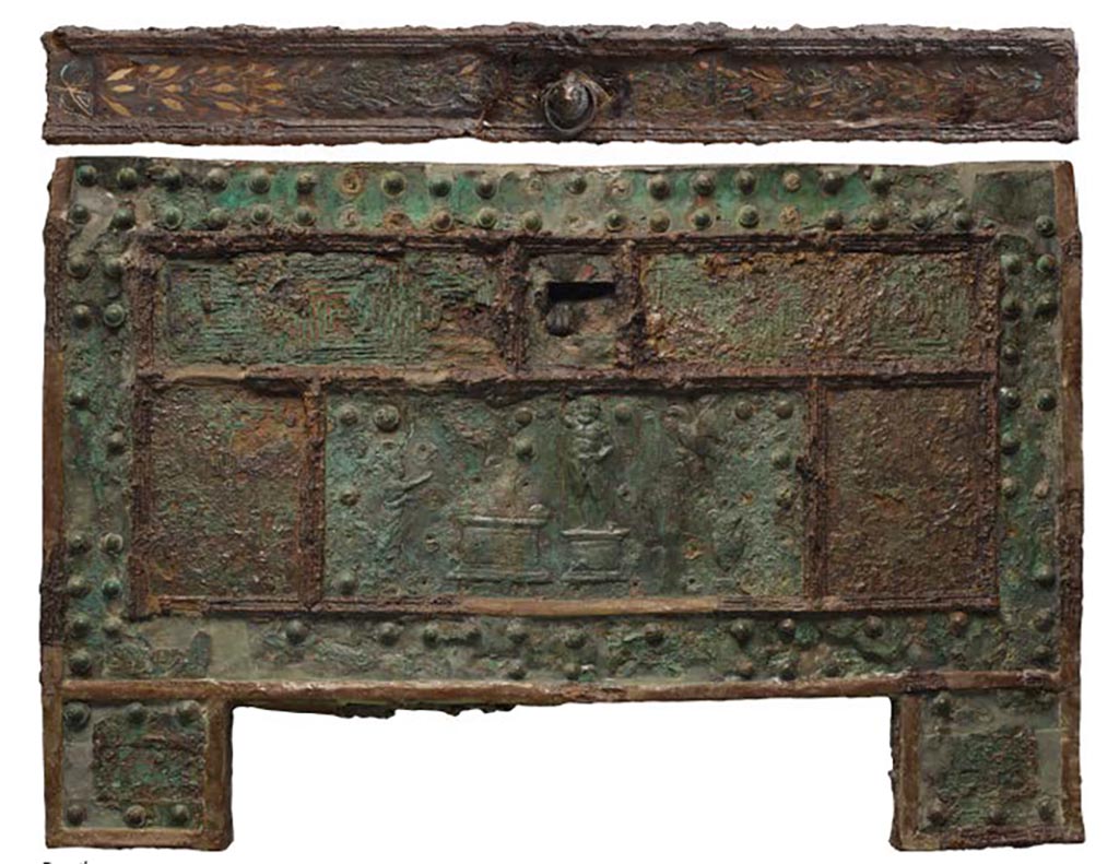 VII.7.5 Pompeii, Found 29 October 1864, now in Naples, Museo Archeologico Nazionale, (inv. 73020).
“Arca”/strong-box with Sacrifice to Jupiter, after restoration, made of wood, with iron and bronze coating; copper bronze and tin.
The strong-box/safe with an offering to Jupiter was discovered in Pompeii on 29 October 1864 in the House of Triptolemus (VII.7.5) 
According to Fiorelli –
…ed immette nell’atrio tuscanico, ove la cassa di ferro pel domestico peculio stava situata sopra un grande pezzo di travertino, ch’e a sinistra della porta d’ingresso: delle sue dipinture rimangono sei Amorini, tutti portanti in mano un corno d’abbondanza.
(trans: “and leads into the Tuscan atrium, where the iron chest for domestic money was placed on a large piece of travertine, which is on the left of the entrance doorway: of its paintings (in the atrium) remain six Cupids, all carrying in their hand a horn of abundance.”)
See Pappalardo, U., 2001. La Descrizione di Pompei per Giuseppe Fiorelli (1875). Napoli: Massa Editore. (p.98)
See Fiorelli, G., 1875. Descrizione di Pompei. Napoli, (p.242).

