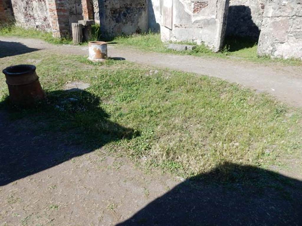 VII.7.10 Pompeii. May 2018. 
Looking north-east across atrium towards east ala, upper centre left, and doorway to cubiculum f, upper right.
The stone slab on the floor between the two doorways would have been for the family “strong-box”. 
The remains of the wooden strong-box were found here, covered by iron and decorated with bronze in relief.
Photo courtesy of Buzz Ferebee. 
