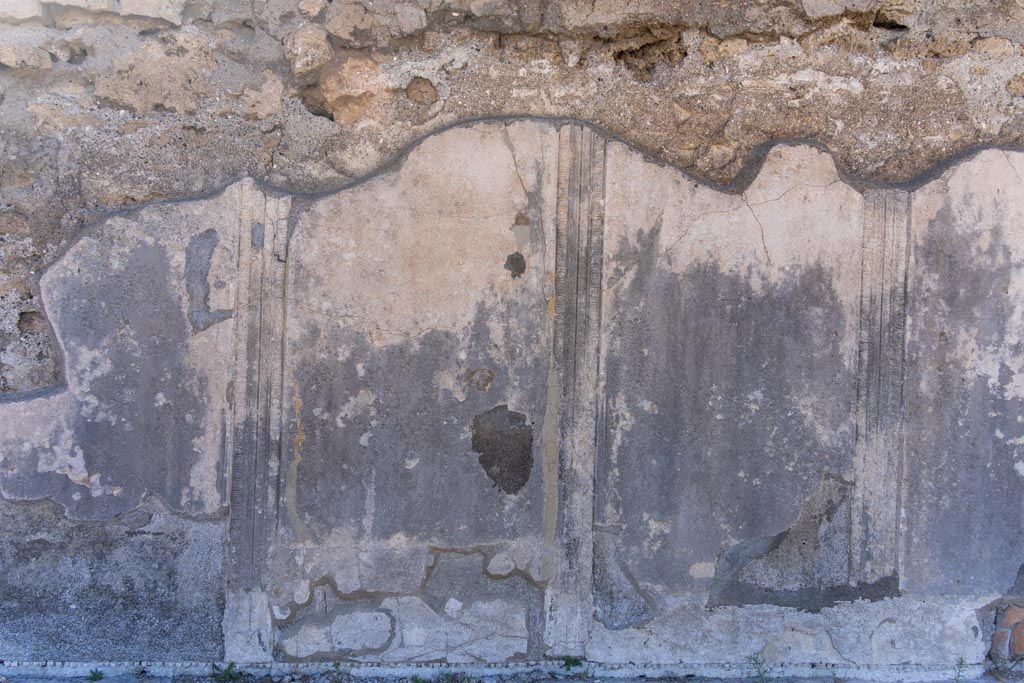 VII.7.32 Pompeii. October 2023. Detail of stucco decoration on exterior east wall of cella. Photo courtesy of Johannes Eber.