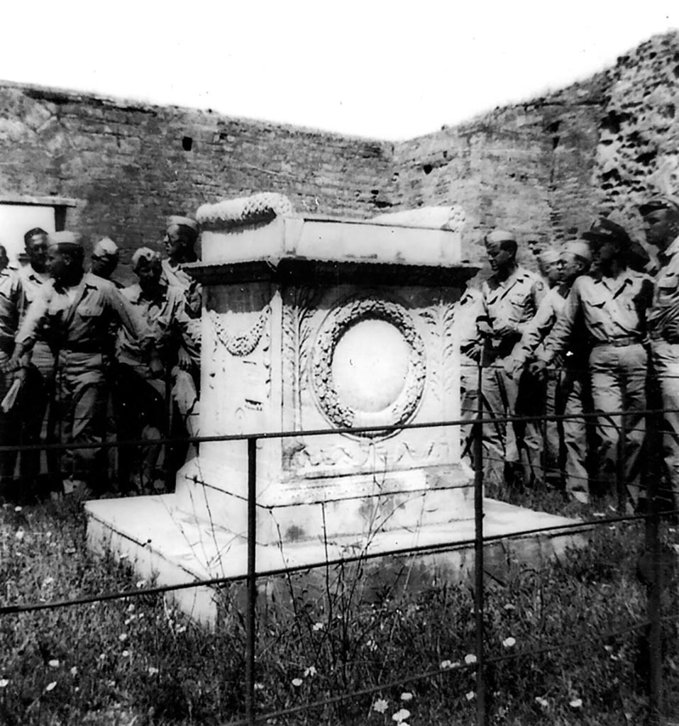 VII.9.2 Pompeii. 1944. East side of altar. Photo courtesy of Rick Bauer.
This side has a crown of oak leaves with a laurel on each side.
According to Mau, the civic crown, one made of oak leaves, and the laurel are recognised as attributes denoting imperial rank.
This temple was therefore built in honour of an emperor.
See Mau, A., 1907, translated by Kelsey F. W. Pompeii: Its Life and Art. New York: Macmillan. (Page 107).
