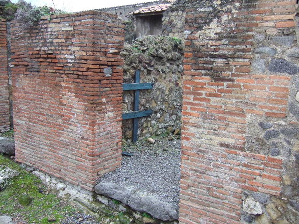 VII.9.31 Pompeii. December 2005. Entrance doorway on west side of Vicolo di Eumachia. 
According to Fiorelli 
VII.9.29-31.
Con due altre botteghe, che costituivano un termopolio termina questa lato dellisola. La prima ha la scaletta, ed una cella dietroposta: la seconda oltre il banco di fabbrica corispondenti scalini, per tenervi sopra bicchieri e stoviglie, ha una seconda gradinata, una della piu interna con focolare ed uscita nei vico ad oriente, e ladito di una scala portante a stanze superiori. Poco discosto leggesi 
C. LOLLIVM.FVSCVM.AED. 
(trans: This side of the insula ended with two other shops, which constituted a thermopolium. The first had the stair-ladder, and a room behind it: the second apart from the masonry bench with corresponding steps/shelves, to keep glasses and dishes on top, had a second stairs, one of the rooms most internal with hearth and exit onto the eastern vicolo, and the entrance doorway to a staircase leading to the upper rooms. Nearby was read 
C. LOLLIUM.FUSCUM.AED.)
See Pappalardo, U., 2001. La Descrizione di Pompei per Giuseppe Fiorelli (1875). Napoli: Massa Editore. (p.106).
