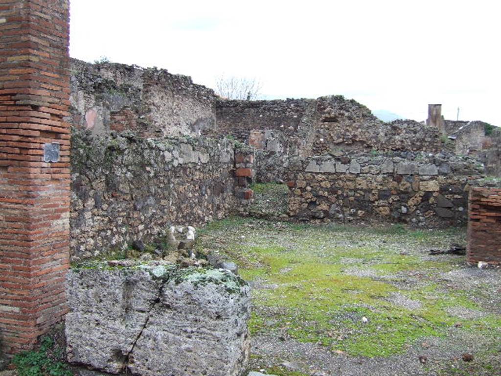 VI.9.37 Pompeii. December 2005. Entrance doorway on Vicolo del Balcone Pensile, with a podium on the left. Looking north into VII.9.36 and to doorway to latrine in north wall, under the stairs at VII.9.35 
