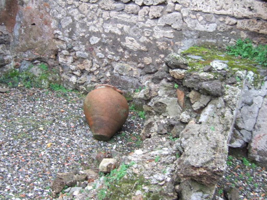 VII.9.49 Pompeii.  December 2005. According to L Eschebach there was a two sided counter with two urns of which one remains.  Is this the terracotta pot shown here?  Above the counter were holes for shelving.  See Eschebach, L., 1993. Gebäudeverzeichnis und Stadtplan der antiken Stadt Pompeji. Köln: Böhlau. (p.317).