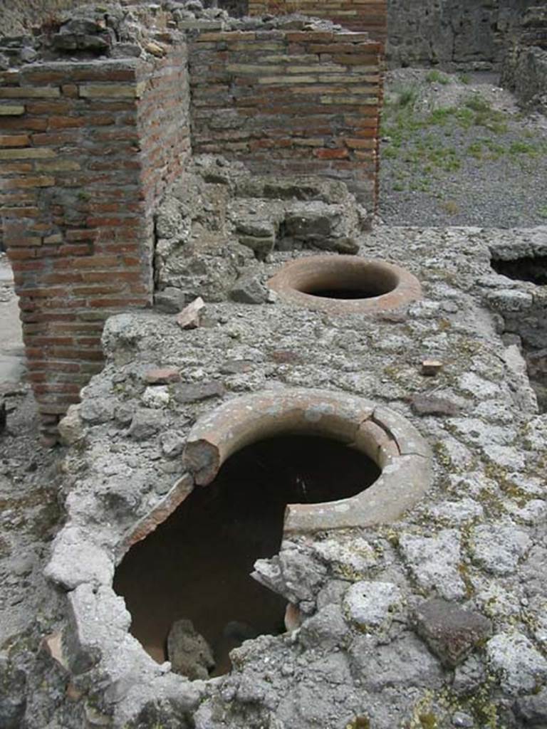 VII.9.54/5 Pompeii. May 2003. Looking east along north counter from rear, with remains of dolia and display shelving. Photo courtesy of Nicolas Monteix.
