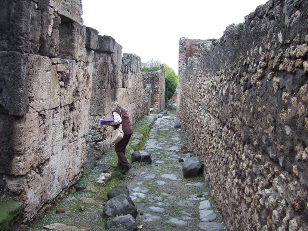 VII.9.64 and VII.9.63 Pompeii. December 2005. Vicolo degli Scheletri looking east. Eumachias building on right.