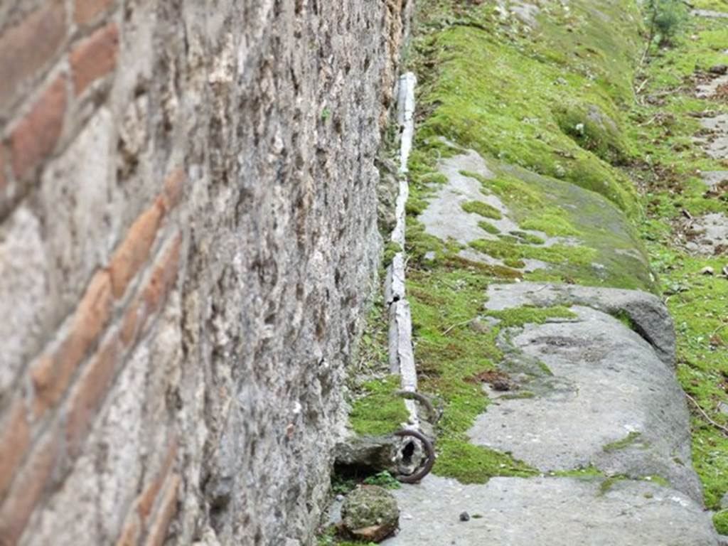 VII.10.9 Pompeii.  March 2009.  Lead pipe in pavement outside entrance, in Vicolo del Balcone Pensile.