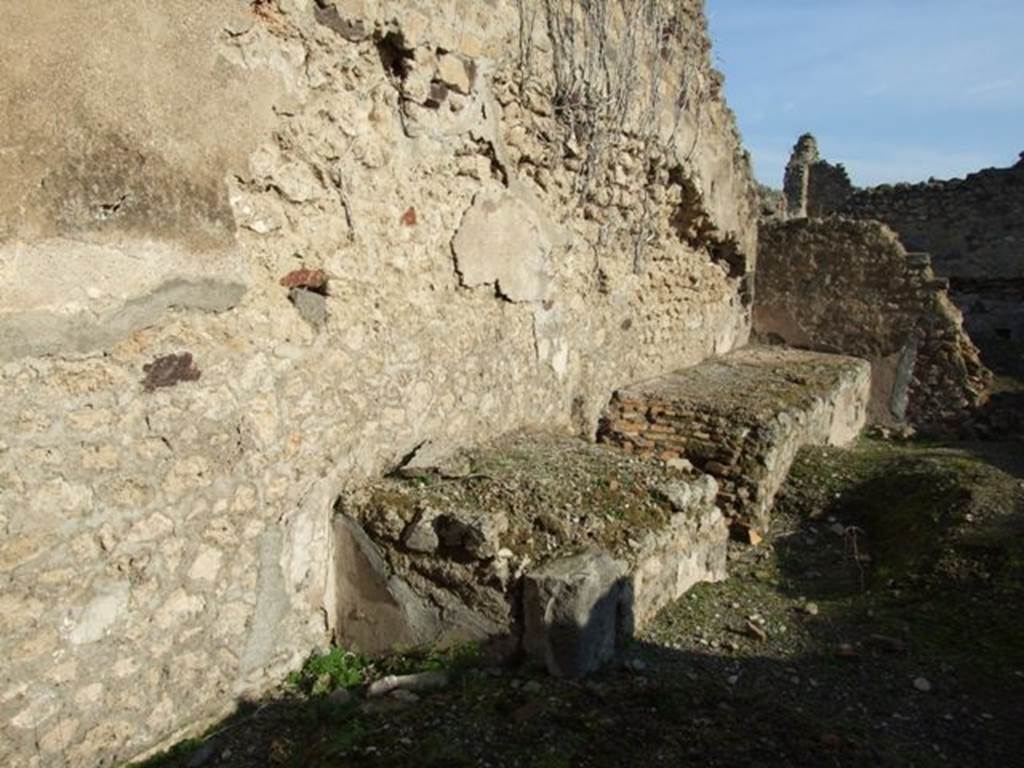 VII.11.3 Pompeii. December 2007. North wall with long podium with hearth and space for cauldron or tub. According to Della Corte, this surely must have been a fullonica. See Della Corte, M., 1965.  Case ed Abitanti di Pompei. Napoli: Fausto Fiorentino. (p. 205)
