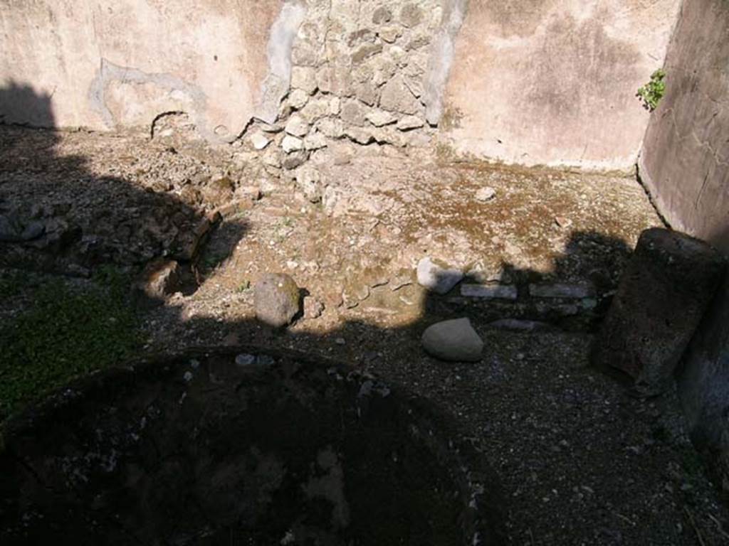 VII.11.5 Pompeii. June 2005. Feature against east wall, and large terracotta pot, in shadow at front. Photo courtesy of Nicolas Monteix.
