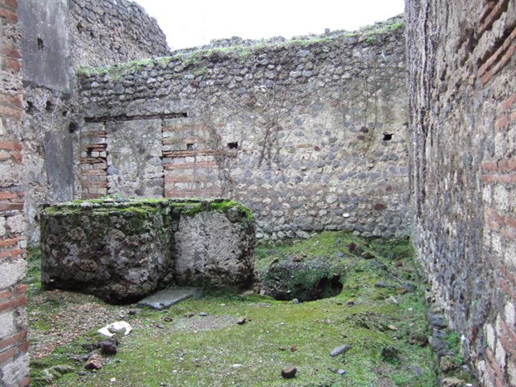 VII.11.7 Pompeii. December 2005. Looking south from entrance.
According to Liselotte Eschebach, this is a stable with livestock watering and feeding rack. 
To the right are holes for brackets, also large beam hole.
In the middle is a large round masonry vat or trough, next to it a well.
See Eschebach, L., 1993. Gebudeverzeichnis und Stadtplan der antiken Stadt Pompeji. Kln: Bhlau, p. 323.
According to PPM, this was a Caupona, originally dependent on the house and communicating with it through a door in the rear room. 
The shop, in the centre, had a counter for serving wine, with an adjoining hearth.
See Carratelli, G. P., 1990-2003. Pompei: Pitture e Mosaici.  Roma: Istituto della enciclopedia italiana., VII, p. 453-5.
