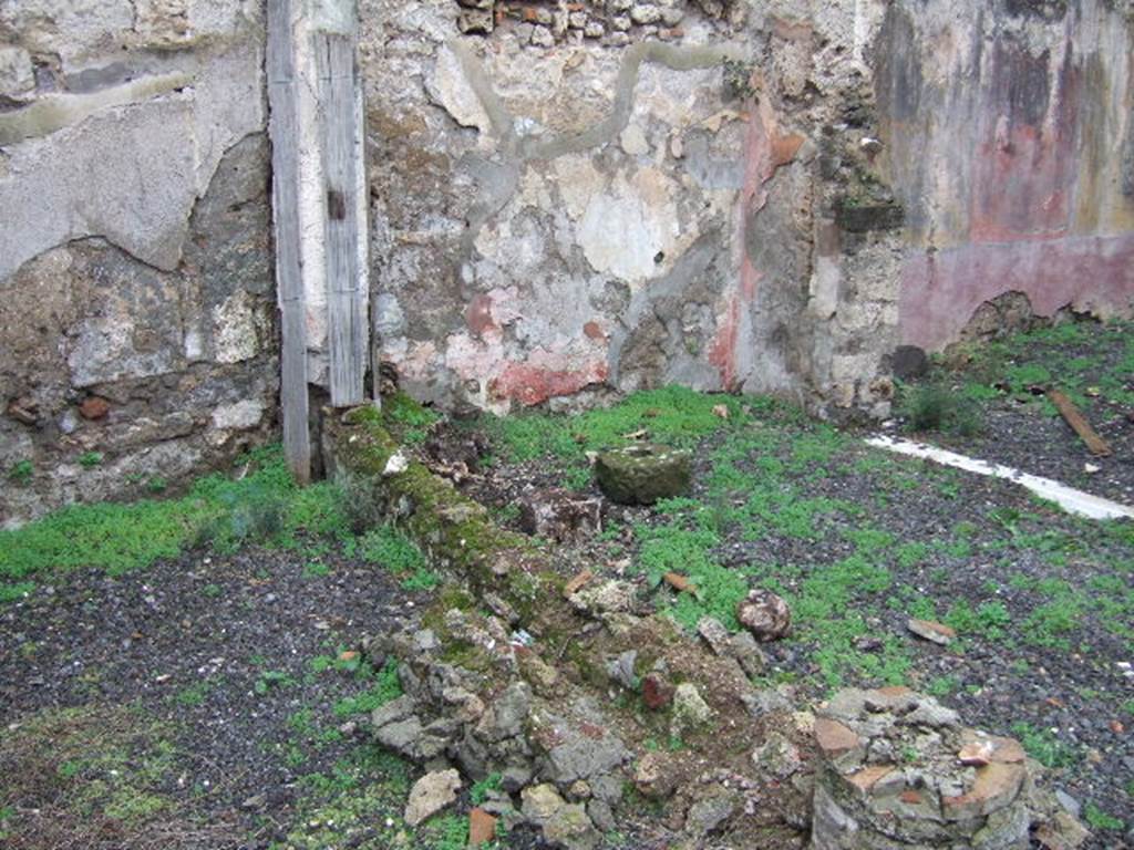 VII.12.26 Pompeii.  West wall of garden area, North Portico and doorway to Triclinium. According to Boyce, there was a Lararium painting on the west end of the North Portico done on a white background. The Genius stood in the centre, with a Lar on either side. Below them, two serpents were approaching an altar. See Boyce G. K., 1937. Corpus of the Lararia of Pompeii. Rome: MAAR 14.  (p.71, No.321).
