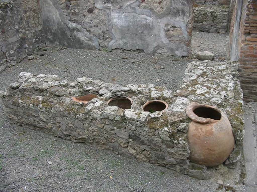 VII.13.20 Pompeii. May 2003. Looking south towards two-sided counter and small hearth, with remaining dolia. Photo courtesy of Nicolas Monteix.
