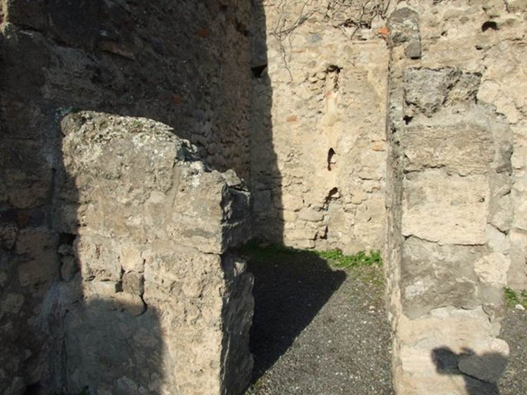 VII.14.2 Pompeii. December 2007. Looking north through doorway to rear room with site of steps to upper floor, and a latrine. According to Boyce, a fragmentary painting on the wall of the kitchen appeared to have belonged to a lararium originally painted above it.  Three men (the heads are missing) are busied about a hog. Below lay the carcass of a slaughtered animal, opened as if for divination from the entrails. He gave the reference – Helbig 83.
See Boyce G. K., 1937. Corpus of the Lararia of Pompeii. Rome: MAAR 14. (p.71, no.325) 
