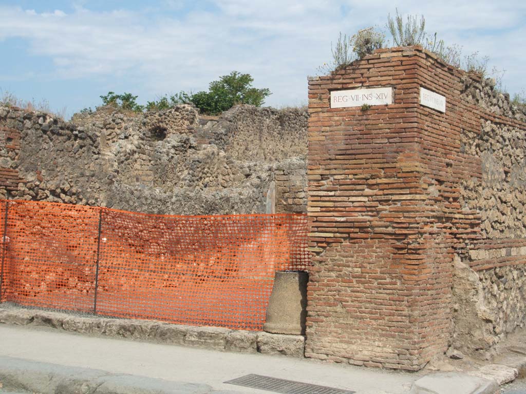 VII.14.14 Pompeii. May 2005. Looking north to shop on corner, and street altar, on right.