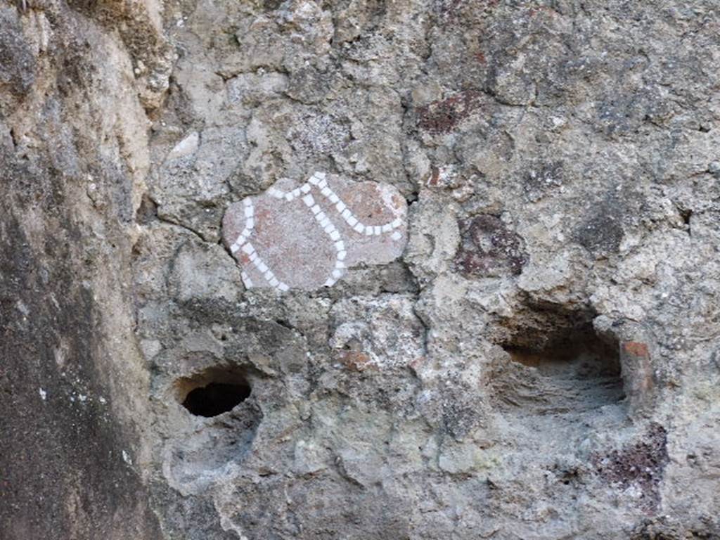 VII.14.15 Pompeii. December 2006. Piece of mosaic on upper west wall in room above small storeroom in north-west corner of garden area.