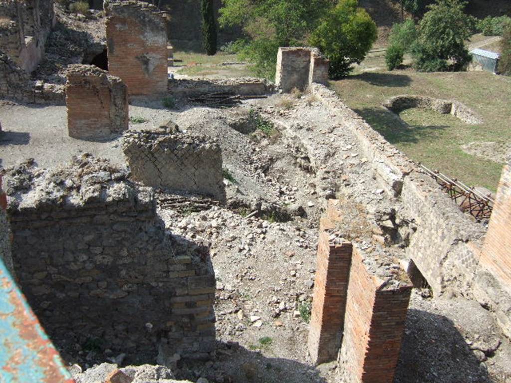 VII.16.16 Pompeii. May 2006. Looking west across rooms 18, 19, 20 and 21 on the lower level. This photograph is indicative of the dangerous state of parts of this house. The floor of room 19 has collapsed into a lower level room. There is also scaffolding supporting the outer wall. The collapse has revealed what appears to be a doorway into the level below these rooms. In the front of the photograph are parts of rooms 23 and 22. 