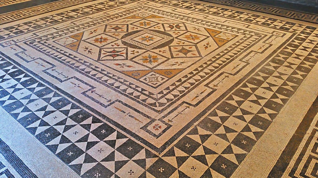 VIII.2.1 Pompeii or Villa Urbana, Varano, Stabia. July 2019.  
Beautiful central emblema of coloured mosaic set into floor in Naples Archaeological Museum, “Magna Grecia” collection. 
Photo courtesy of Giuseppe Ciaramella.
It is thought this central emblema may be from this house, now seen re-set into another mosaic floor.
Many artists in the 19th century have seen and drawn this mosaic in Naples Museum.
According to Abbate, this mosaic was from either Stabia or Pompeii.
According to Real Museo Borbonico, vol.15, tav 24 (XXIV), this mosaic is from the Villa of Tiberius on Capri. 
According to Pisapia, this mosaic is from Stabia, Villa Urbana.
See Pisapia, M. S. 1989, in Mosaici antichi in Italia, Regione prima. Stabia, Roma, (p.67-70, no.124).


