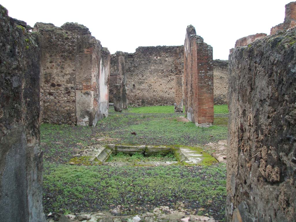 VIII.2.13 Pompeii. December 2004. Looking west from entrance to atrium with impluvium and pseudo-peristyle, at rear.
According to Jashemski, the garden at the rear of the tablinum was enclosed on the east and south by a portico supported by columns.
See Jashemski, W. F., 1993. The Gardens of Pompeii, Volume II: Appendices. New York: Caratzas. (p.205)
According to Garcia y Garcia, due to the bombing in 1943 there was destruction to part of the ala on the north of the portico.
Two columns of the portico also fell down.
See Garcia y Garcia, L., 2006. Danni di guerra a Pompei. Rome: L’Erma di Bretschneider. (p.139)
