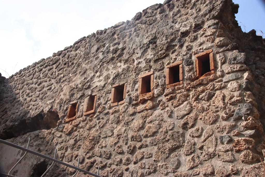 VIII.2.38 Pompeii. October 2023. 
West wall of shop-room, with holes for support beams for an upper floor. Photo courtesy of Klaus Heese.
