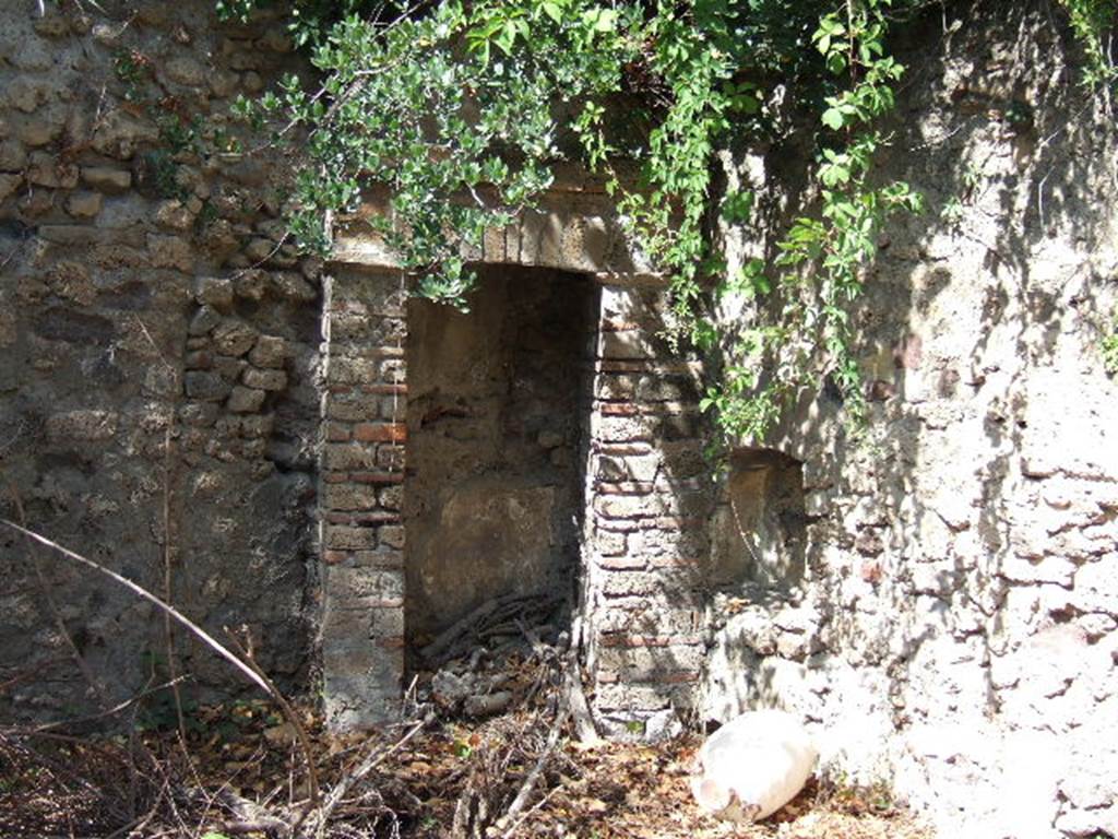 VIII.3.14 Pompeii. September 2005. North-west corner of garden.
According to Boyce, in the north-west corner of the garden was a niche adorned with an aedicula facade.  There were two rectangular pilasters supporting a pediment, and built on the top of a base. Before the aedicula stood an altar. 
See Boyce G. K., 1937. Corpus of the Lararia of Pompeii. Rome: MAAR 14. (p.75, no.351). 
