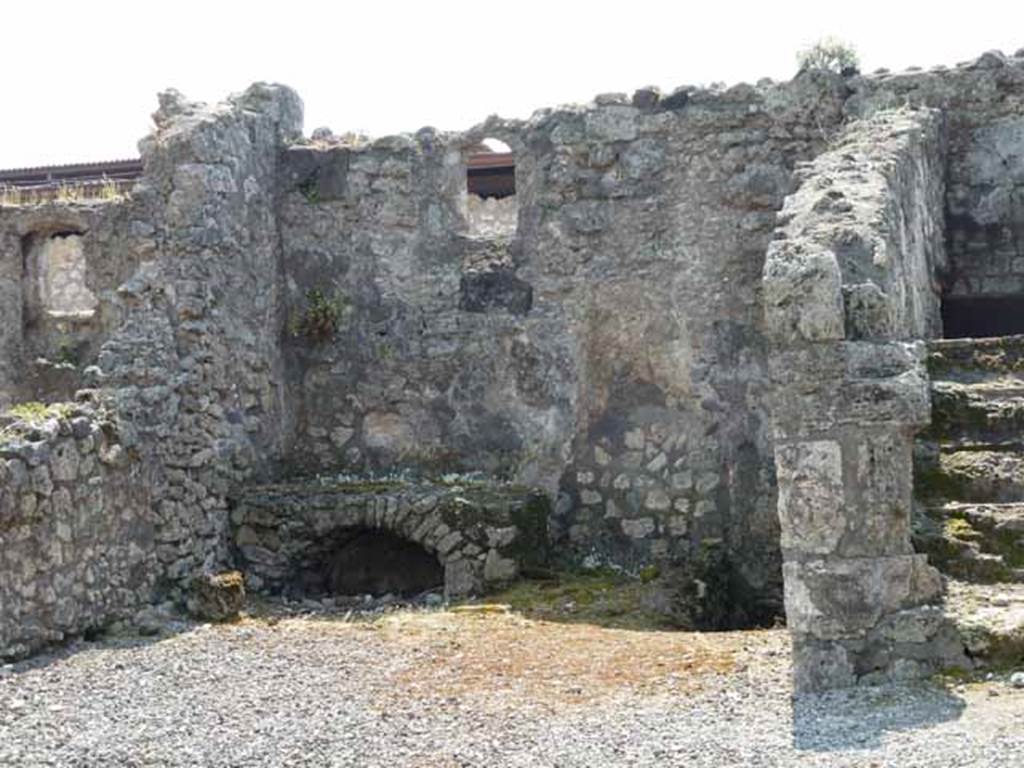 VIII.3.18 Pompeii. May 2010. Looking south towards right ala, being used as a kitchen with hearth. Taken from VIII.3.19.  A niche latrine can be seen on the west (right side) of the hearth.
See Hobson, B., 2009. Pompeii, Latrines and Down Pipes. Hadrian Books (p.440 and photo p.444) 
According to Boyce, Helbig saw a fragmentary lararium painting with the figure of the Lares, in the kitchen. (Helbig 91).
See Boyce G. K., 1937. Corpus of the Lararia of Pompeii. Rome: MAAR 14. (p.76, no.355)  See Helbig, W., 1868. Wandgemälde der vom Vesuv verschütteten Städte Campaniens. Leipzig: Breitkopf und Härtel. (no.91)
