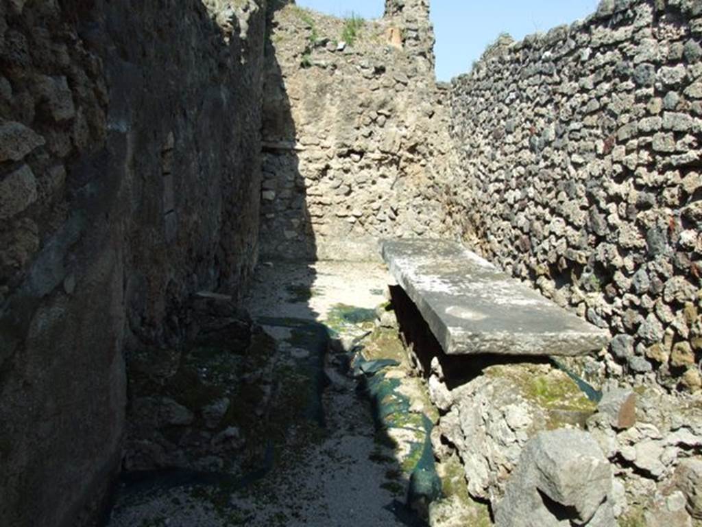 VIII.4.4 Pompeii. March 2009. Room 7, kitchen, with small basin and long marble top. Looking north. The kitchen contained not only a hearth, worktable and latrine, but also three basins or masonry structures. 
A fourth structure or basin in the peristyle colonnade was connected to the kitchen through an opening. 
