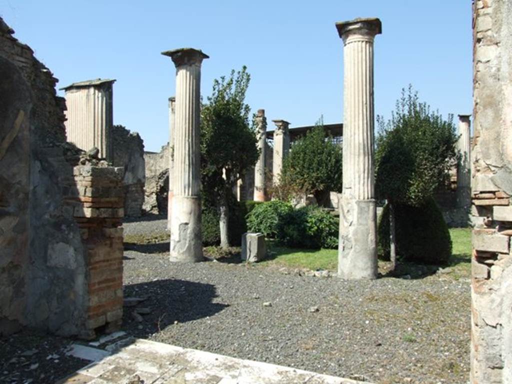 VIII.4.4 Pompeii. March 2009. Room 11, exedra.  Looking north from door threshold.  
View across garden, including the base of the fountain statuette shown in the pictures below.
According to Dyer: 
“Over the roof of the portico, supported by the pillars, ran a gallery with another set of columns, reached by a staircase near the tablinum.
The peristyle is simply decorated. 
The lower third of the columns having the channelling only marked with lines, is painted red, while the upper (and channelled part) is white.
The walls are black, and adorned with small pictures of eatables, separated by ornaments. 
The border at the bottom is painted with water-plants and water-fowl.
On the wall on the right (of the peristyle) was a graffito, to the following effect:
“July 7th, lard 200lb, garlic 250 bundles” meaning probably that these things were either bought or sold on that day.”
See Dyer, Thomas, 1867: The Ruins of Pompeii. London: Bell and Daldy, (p.80).