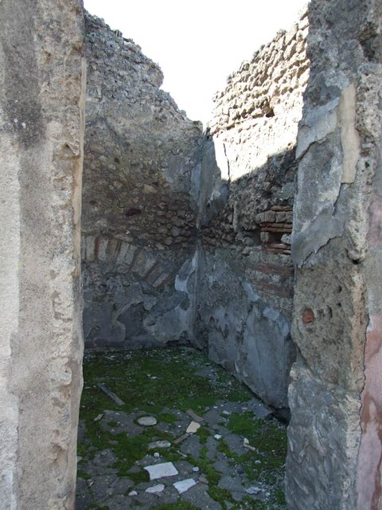 VIII.4.4 Pompeii. March 2009. Room 23, north-west corner of room linked to VIII.4.3.  
According to Fiorelli, this room was excavated on the dates of 9th and 18th January and 6th February 1861, and had two doors, one linking to the shop at VIII.4.3 and the other into the atrium of VIII.4.4. It was found decorated only with white walls with some red lines and yellow meanders, in the middle were two painted candelabra, a large urn and another vase of uncertain form; there were no central paintings on its walls. The beaten floor had a few pieces of coloured marble in it, the threshold was of vesuvian stone, the lower podium of the walls were carelessly painted with the same aquatic plant leaves that were seen in the atrium. Remaining in their original site were – the bronze hinges of the two doors, and with them the locks, three nails, and a ring with flange, other iron nails, four pieces of cylindrical bone, and a terracotta jar in the form of an “ampulla”.
See Fiorelli, Giornale degli Scavi, 1861, (p.19)
