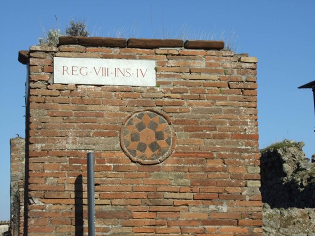 Decorative plaque on side wall of VII.4.1 near entrance to VIII.4.53.  March 2009.